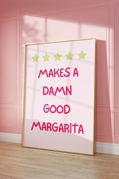 a pink room with a framed sign that says makes a damn good margarita