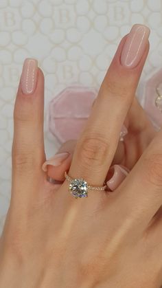 a woman's hand with a ring on her finger and a diamond in the middle