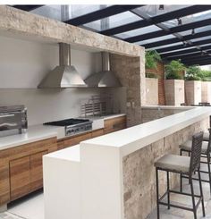 an outdoor kitchen with counter tops and stools