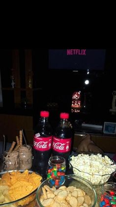 a table full of snacks and drinks on it's side, along with two bottles of coca - cola