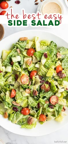 a salad with lettuce, tomatoes and other vegetables in it on a white plate