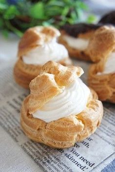 three small pastries sitting on top of a newspaper