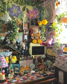 a room filled with lots of stuffed animals and decorations on the wall above a computer monitor