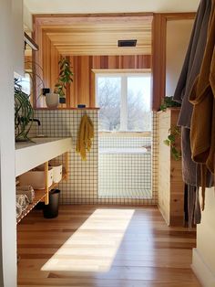 the sun shines through the window into a bathroom with wood flooring and tiled walls