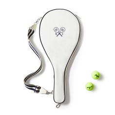 a tennis racket and three balls on a white surface