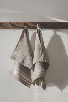 two folded towels hanging on a wooden bar