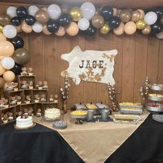 a table with desserts and balloons on it