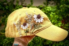 a person wearing a yellow hat with daisies on it