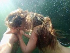 two people are kissing under the water