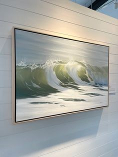 a large painting hanging on the wall next to a white wall with wooden planks