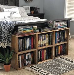 a bed sitting next to a wooden book shelf filled with books on top of a rug