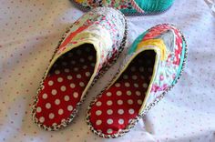 two pairs of slippers sitting on top of a bed