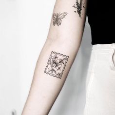 a woman with a tattoo on her arm holding a butterfly and flower in the background