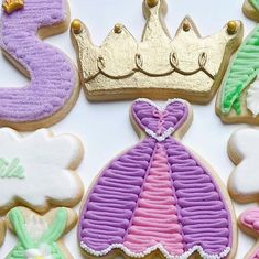 decorated cookies are arranged in the shape of princess's dress and tiables