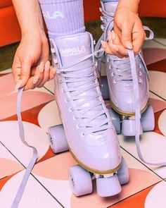 a close up of a person wearing roller skates on a tiled floor with pink and white tiles