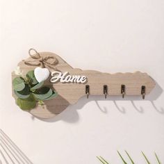 a wooden coat rack with hooks and flowers on the top, along with some leaves