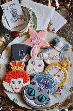 decorated cookies are on a plate next to an envelope and other items in the background