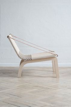 a white chair sitting on top of a hard wood floor in front of a wall