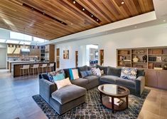 a living room filled with lots of furniture and a fire place under a wooden ceiling