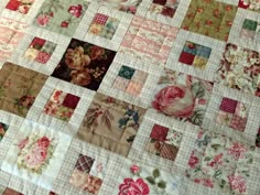 a close up of a patchwork quilt with flowers on it