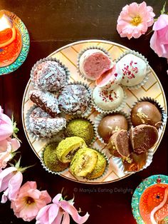 there are many different types of pastries on the plate with pink flowers around them