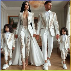 a man and woman in white outfits standing next to each other with their child on the floor