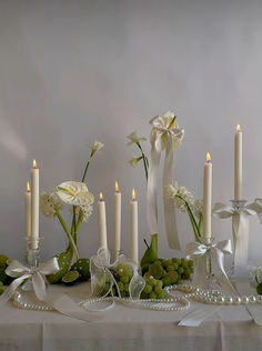 a table topped with white flowers and candles