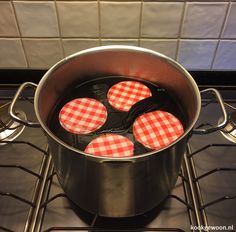 four red and white checkered coasters in a pot on the stove