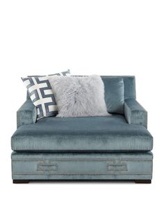 a blue couch with two pillows on it's back and one pillow in the middle