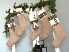 three christmas stockings hanging from the side of a fireplace with snowmen and plaid bows on them