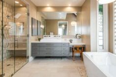 a large bathroom with two sinks and a bathtub next to a walk in shower