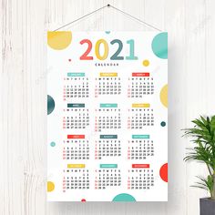 a calendar hanging on a wall next to a potted plant in front of it