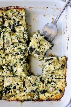 spinach and cheese casserole in a white dish with a fork on the side