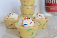 small cupcakes with white frosting and sprinkles are on a plate