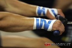 two hands with blue and white wrist bands