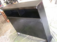 a metal cabinet sitting on top of a tarp covered floor