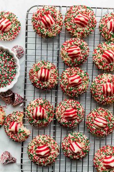 christmas sprinkle cookies on a cooling rack with candy canes and candies