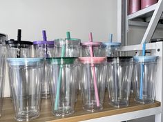 many different colored tumblers lined up on a shelf