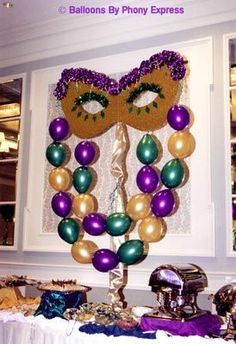 a mardi gras decoration with purple, green and gold balloons