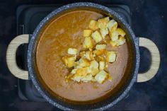 a pot filled with food sitting on top of a stove