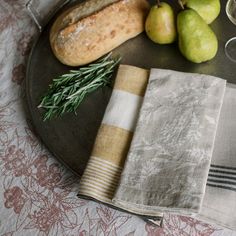 a plate with napkins, pears and bread on it