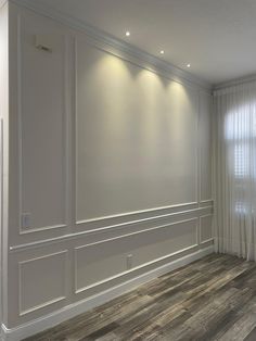 an empty room with white walls and wood floors