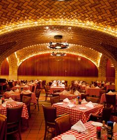 the inside of a restaurant with red and white checkered tablecloths on tables