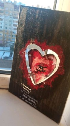 a painting on a window sill in front of a building with the words happy valentine's day written on it