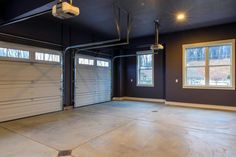 an empty garage with two overhead doors and no one in the room or on the ground