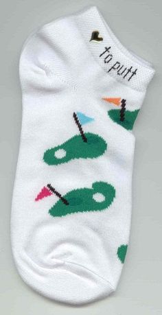 a pair of white socks with green and red golf balls on them, that say to put