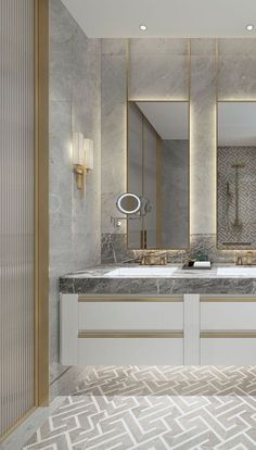 a bathroom with marble counter tops and gold trim on the mirror above the double sinks