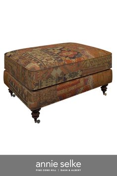 an antique ottoman with wheels on the bottom and foot rest, is upholstered