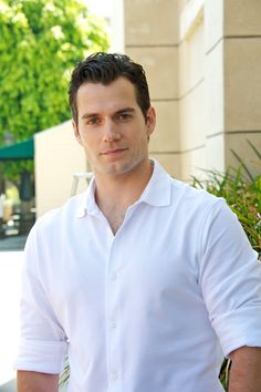 a man standing in front of a building wearing a white shirt