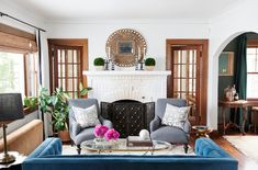 a living room with two blue couches and a fire place in the center area